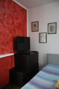 Un dormitorio con una cama y un televisor de pantalla plana. en Nottetempo, en Desio