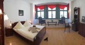 a bedroom with a large bed and a living room at Altstadthotel Garni Schlundhaus & Rautenkranz in Meiningen