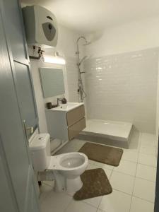 a white bathroom with a toilet and a sink at Studio moderne à Saint-François, 38 m² avec piscine in Saint-François