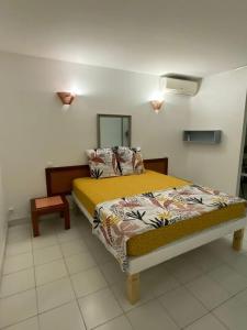 a bedroom with a bed with a yellow comforter at Studio moderne à Saint-François, 38 m² avec piscine in Saint-François