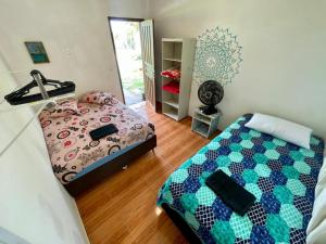 a bedroom with a bed and a mirror in it at Jardins do Rosa - Hospedagem e Entretenimento in Imbituba