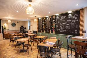 un restaurante con mesas y sillas de madera y una pizarra en Un grain d'folie, en Villié-Morgon