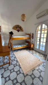 een kamer met een bed, een stoel en een tapijt bij Villa Anna in Quartu Sant'Elena