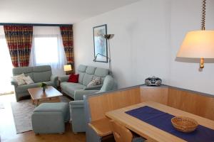 Ferienhaus Nr 46, Kategorie Komfort L, Feriendorf Hochbergle, Allgäu في Karlsebene: غرفة معيشة بها أريكة وطاولة