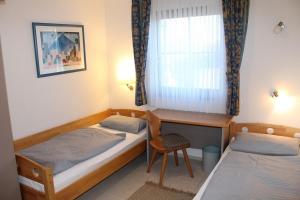 Ferienhaus Nr 46, Kategorie Komfort L, Feriendorf Hochbergle, Allgäu في Karlsebene: غرفة بسريرين ومكتب ونافذة +11 صورة