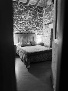 a bedroom with a bed in a stone wall at Casa Solle - Bonita casa de montaña a 20 min de San Isidro 