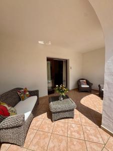a living room with chairs and a couch and a table at Villa Pinna in San Teodoro