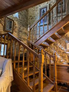 a wooden staircase in a room with a stone wall at Casa Solle - Bonita casa de montaña a 20 min de San Isidro  +52 photos