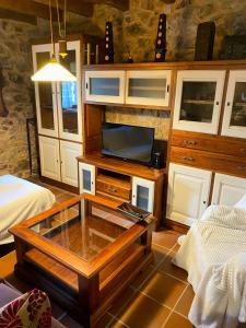 a living room with a coffee table and a tv at Casa Solle - Bonita casa de montaña a 20 min de San Isidro 