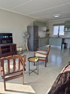 een woonkamer met stoelen en een keuken bij Sand & Sea Studio Hermanus in Hermanus