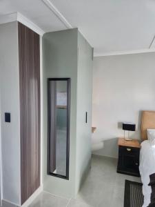 een hotelkamer met een spiegel en een bed bij Sand & Sea Studio Hermanus in Hermanus +3 foto's