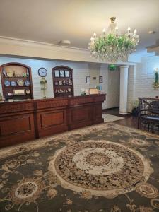 een lobby met een kroonluchter en een groot tapijt bij Arien Plaza in Muruntau