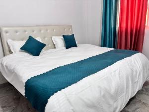 a large bed with blue pillows in a bedroom at R D Palace and Resort in Bhauli