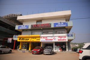 a hotel with cars parked in front of it at Teja Hotel in Lūnāvāda
