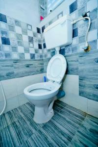 a bathroom with a white toilet in a room at Bhakti Bliss Homestay - New Luxury 2bhk apartment in Tirupati with Kitchen and car parking in Tirupati