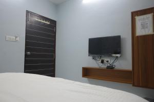 a bedroom with a bed and a flat screen tv at Teja Hotel in Lūnāvāda