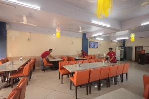 a restaurant with people sitting at tables and chairs at Teja Hotel in Lūnāvāda