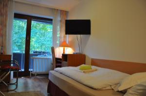 a bedroom with a bed and a desk and a window at Waldpension Bielefeld in Bielefeld