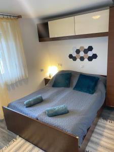 a bedroom with a large bed with blue pillows at Jázmin Apartmanok Mórahalom in Mórahalom