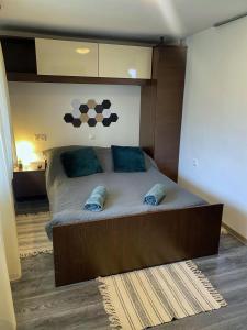 a bedroom with a large bed with blue pillows at Jázmin Apartmanok Mórahalom in Mórahalom