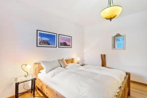 a bedroom with a large bed with white sheets at Ferienwohnung am Schmenkenberg in Marsberg