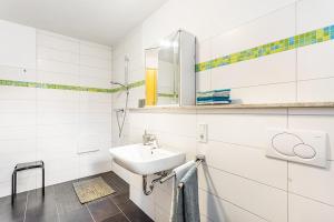 a white bathroom with a sink and a mirror at Ferienwohnung am Schmenkenberg in Marsberg +25 photos