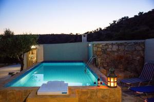 a swimming pool with a table and two chairs at Triopetra Green Dream in Triopetra