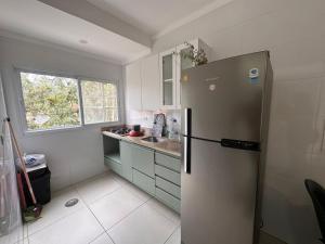 a kitchen with a stainless steel refrigerator and a window at Apartamento pé na areia no centro de Bertioga in Bertioga +13 photos