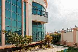 a large building with glass windows and palm trees at Full Moon Guesthouse in Dubai