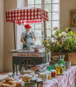 Chateau de Gudanes في Château-Verdun: امرأة تقف أمام طاولة مع الطعام