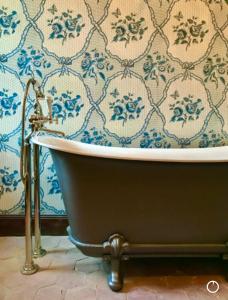 Chateau de Gudanes في Château-Verdun: حوض الاستحمام في الحمام ورق الجدران الأزرق والأبيض +11 صورة