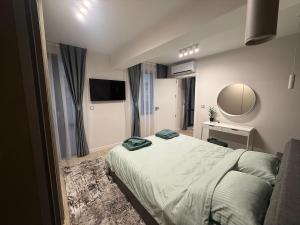 ein Schlafzimmer mit einem großen Bett und einem Spiegel in der Unterkunft ElMar Apartment - ЕлМар Апартмент in Yambol