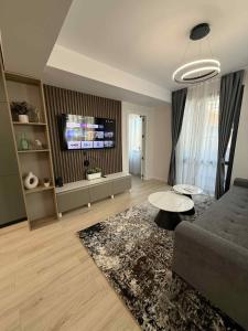 ein Wohnzimmer mit Sofa und Fernseher in der Unterkunft ElMar Apartment - ЕлМар Апартмент in Yambol