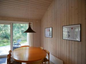a dining room with a wooden table and a window at Summerhouse in Ulvshale, Møn in Stege