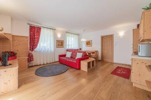 een woonkamer met een rode bank en een tafel bij Dolomites Essence in Falcade