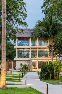 a house with a palm tree in front of it at Samaraya Wellness Resort in Amphoe Koh Samui