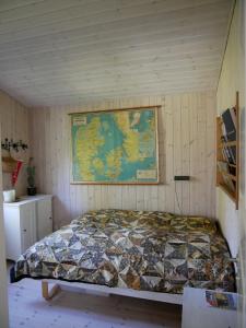a bed in a room with a map on the wall at Summerhouse in Ulvshale, Møn in Stege