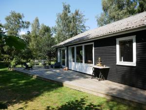 a large wooden deck next to a house at Summerhouse in Ulvshale, Møn in Stege