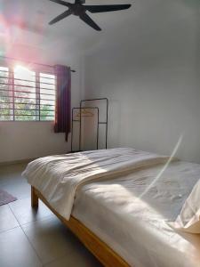 a bedroom with a large bed with a ceiling fan at Grace Homestay Taiping in Taiping