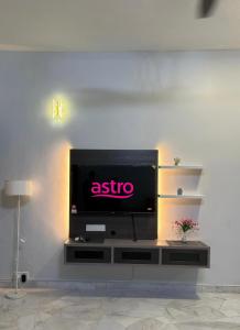 a flat screen tv sitting on top of a entertainment center at Grace Homestay Taiping in Taiping