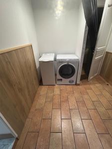 comfortable wooden chalet for family stay في أتيس مو: غسالة ومجفف في الحمام مع باب