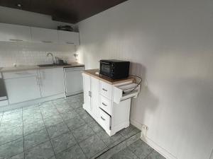 comfortable wooden chalet for family stay في أتيس مو: مطبخ بدولاب أبيض وميكرويف أسود +4 صور