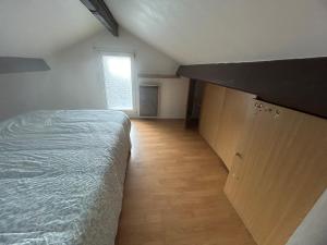 comfortable wooden chalet for family stay في أتيس مو: غرفة نوم صغيرة بها سرير ونافذة