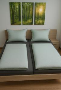 two beds in a room with paintings on the wall at Walldürn Zentrum 1 in Walldürn