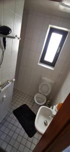a bathroom with a sink and a toilet with a window at Walldürn Zentrum 1 in Walldürn
