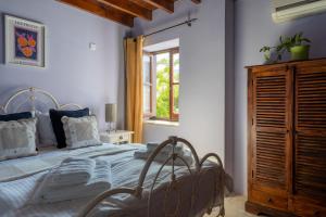 a bedroom with a large bed and a window at Villa Monti Cozy Yard & BBQ Perfect for Families & Friends in Kato Lefkara