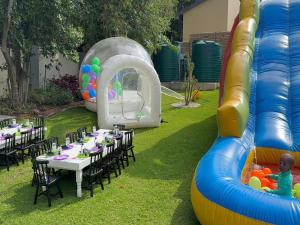an outdoor party with tables and an inflatable slide at Fezeu's Place in Johannesburg +75 photos