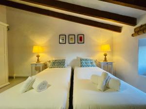 two twin beds in a room with two lamps at Sant Miquel in Campanet