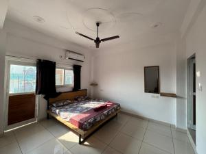 a bedroom with a bed and a ceiling fan at Happy Homes by Yoga & Smiles, Upper Tapovan in Rishīkesh