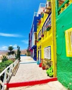 Un edificio colorido al lado de una playa. en Aghrour Village & Timlaline Dunes Adventure, en Taghazout